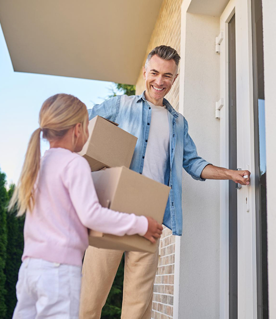father and daughter carrying moving boxes