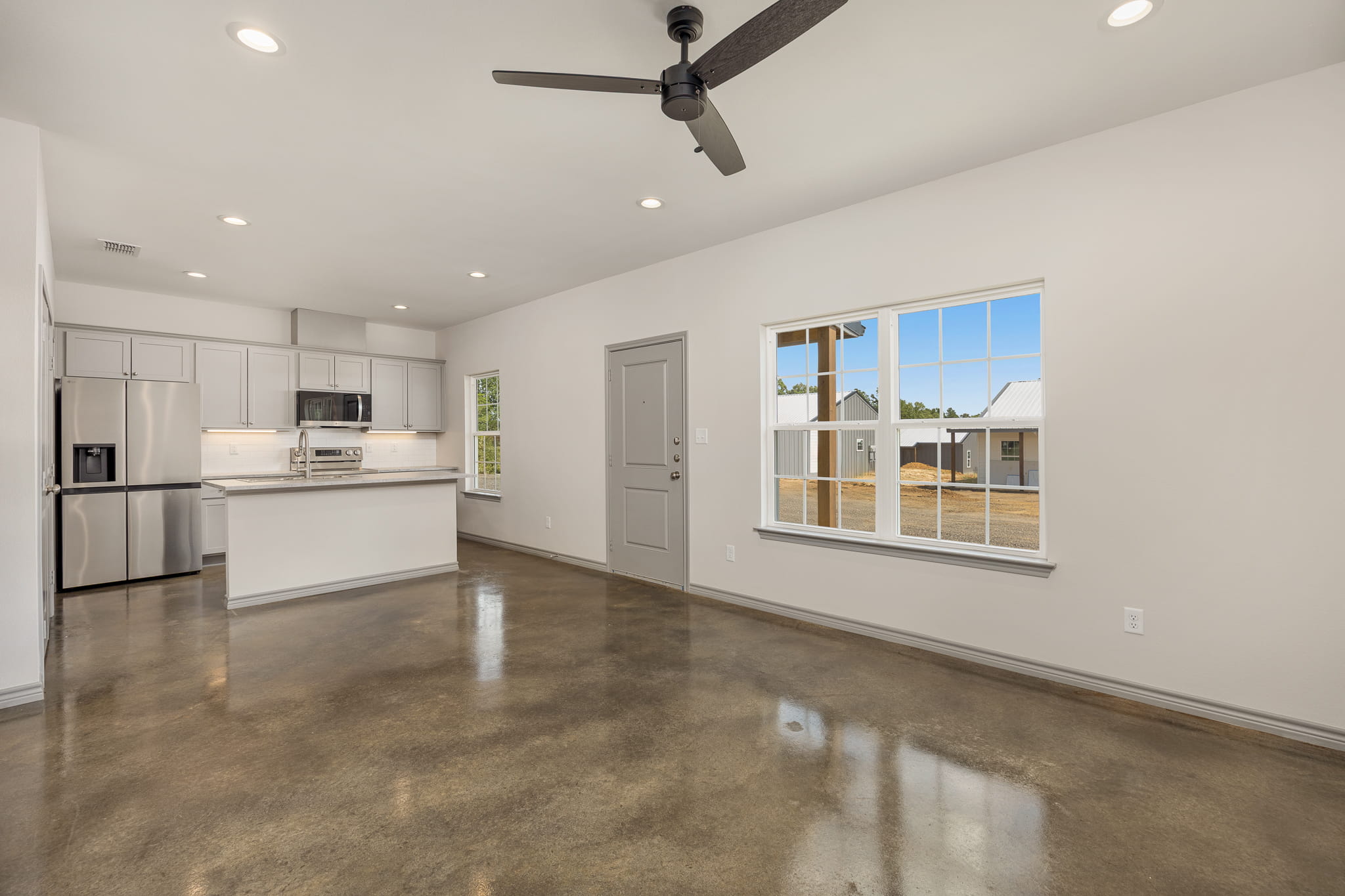 living room and kitchen with shiny concrete floor